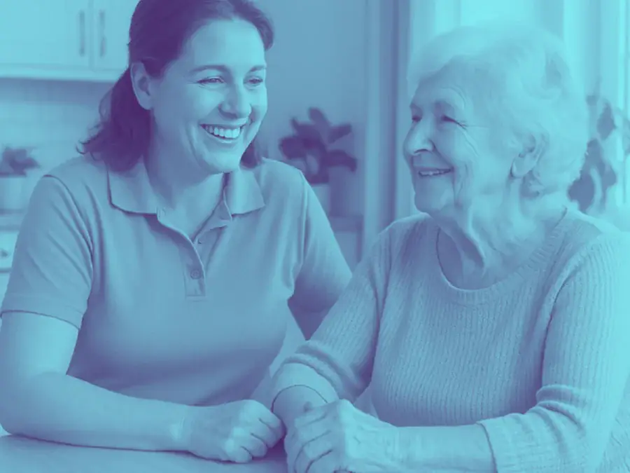 An in-home care team member visiting with an older adult